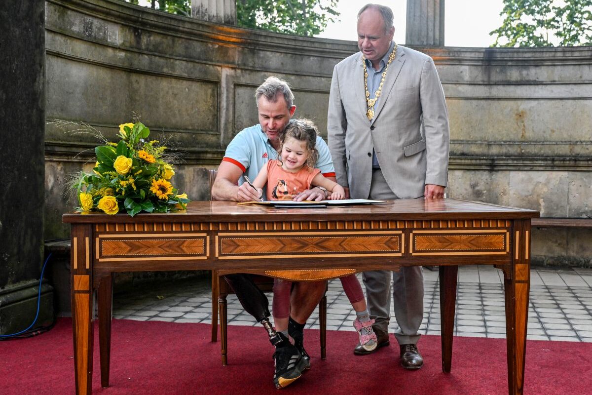 Sitzvolleyballer Alexander Schiffler mit seiner Tochter und Oberbürgermeister Dirk Hilbert