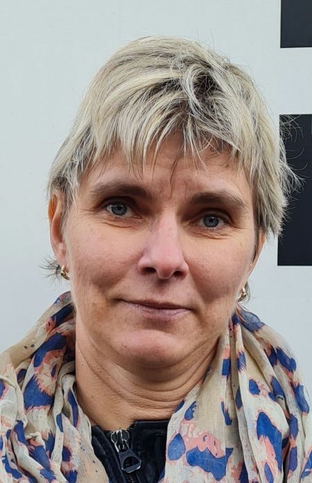 Dörte Leistikow - Portrait einer blonden Frau mittleren Alters mit Ohrringen und einem leichten Tuch um den Hals
