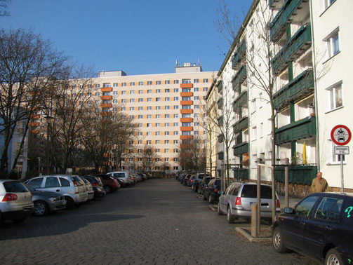 Das Bild aus der Johannstädter Blumenstraße zeigt komplexen Wohnungsbau in Zeilen- und Blockbauweise, einen Quartierstreff (links) sowie straßenbegleitendes Parken