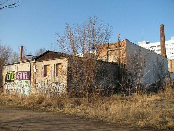 Das Bild zeigt die nahezu ruinös wirkende Schokofabrik an Rande der Großbrache 'Plattenwerk', die als Standort mehrerer Ateliers und Büros der Kreativszene Modernisierungsbedarf und Erweiterungsprotenzial aufweist.