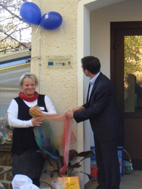 Herr Bürgermeister Seidel und die Leiterin der Kita, Frau Schilling, bei der Enthüllung des EFRE-Hinweisschildes zur feierliche Wiedereröffnung am 17. Oktober 2012