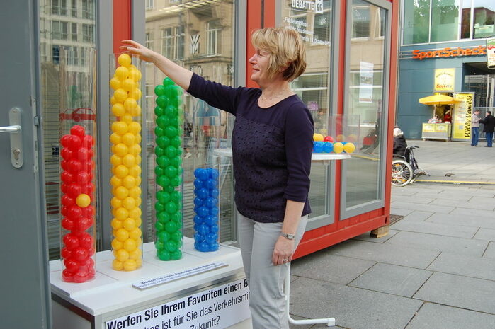 im Bild ist der "Ballo-Split" dass heißt 4 Plexisäulen die mit Bällen bestückt sind zu sehen vor der Info-Box zur 3. Dresdner Debatte zur Verkehrsmittelnutzung der Zukunft