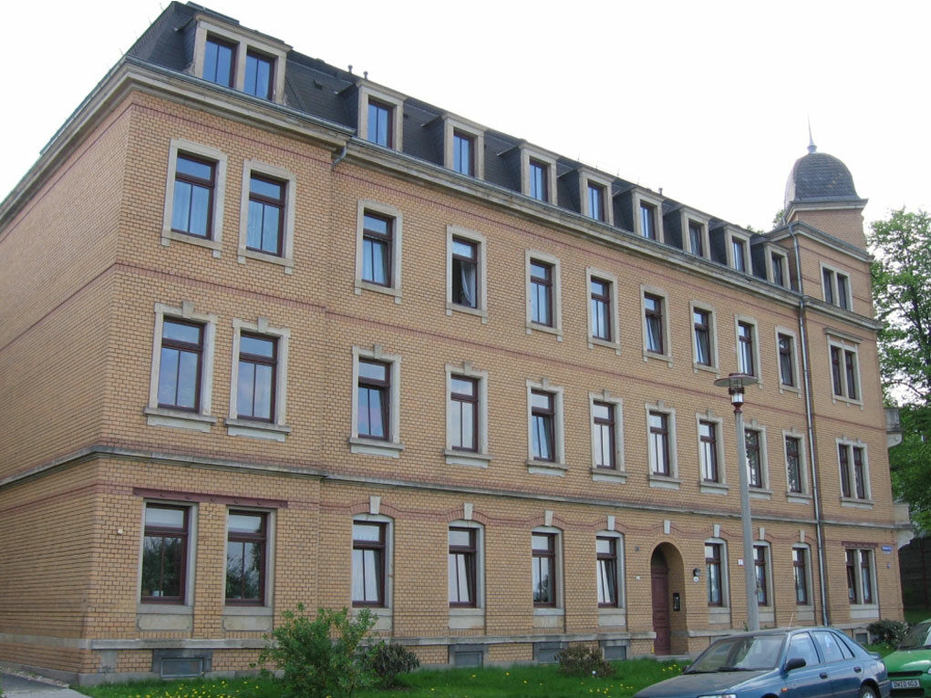 Auf dem Foto ist ein saniertes Wohnhaus auf der Lübecker Str. zu sehen. Es ist ein schlichtes Gründerzeitgebäude mit einer orangefarbenen Klinkerfassade.