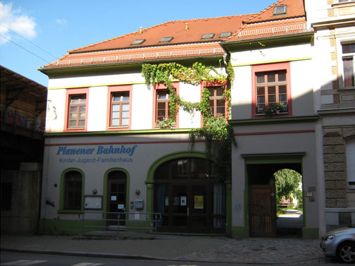 Das Foto zeigt den ehemaligen Plauener Bahnhof mit sanierter Fassade und Weinbewuchs.