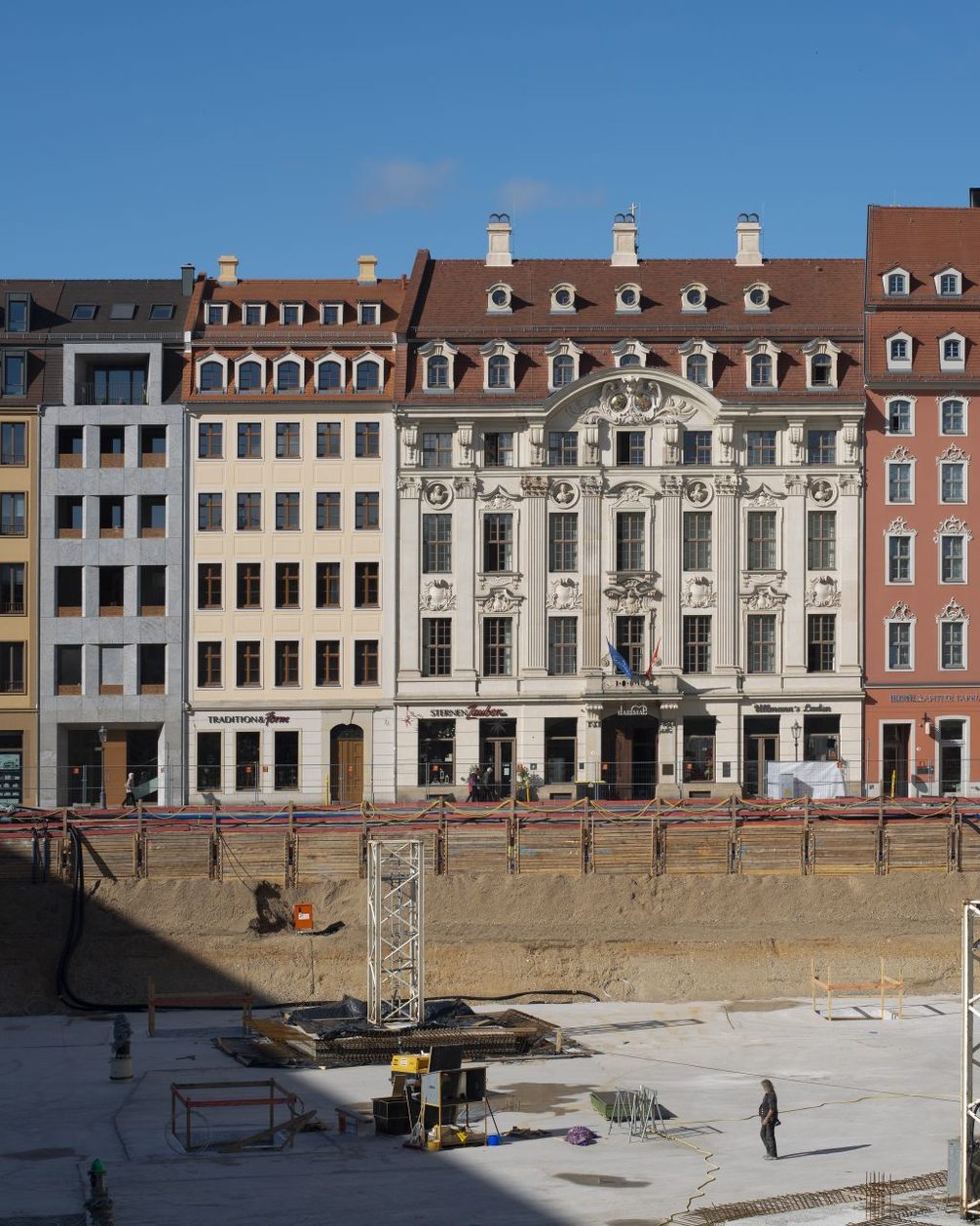 Blick über die Baugrube des Quartier III auf die rekonstruierte historische Fassade des British Hotel.