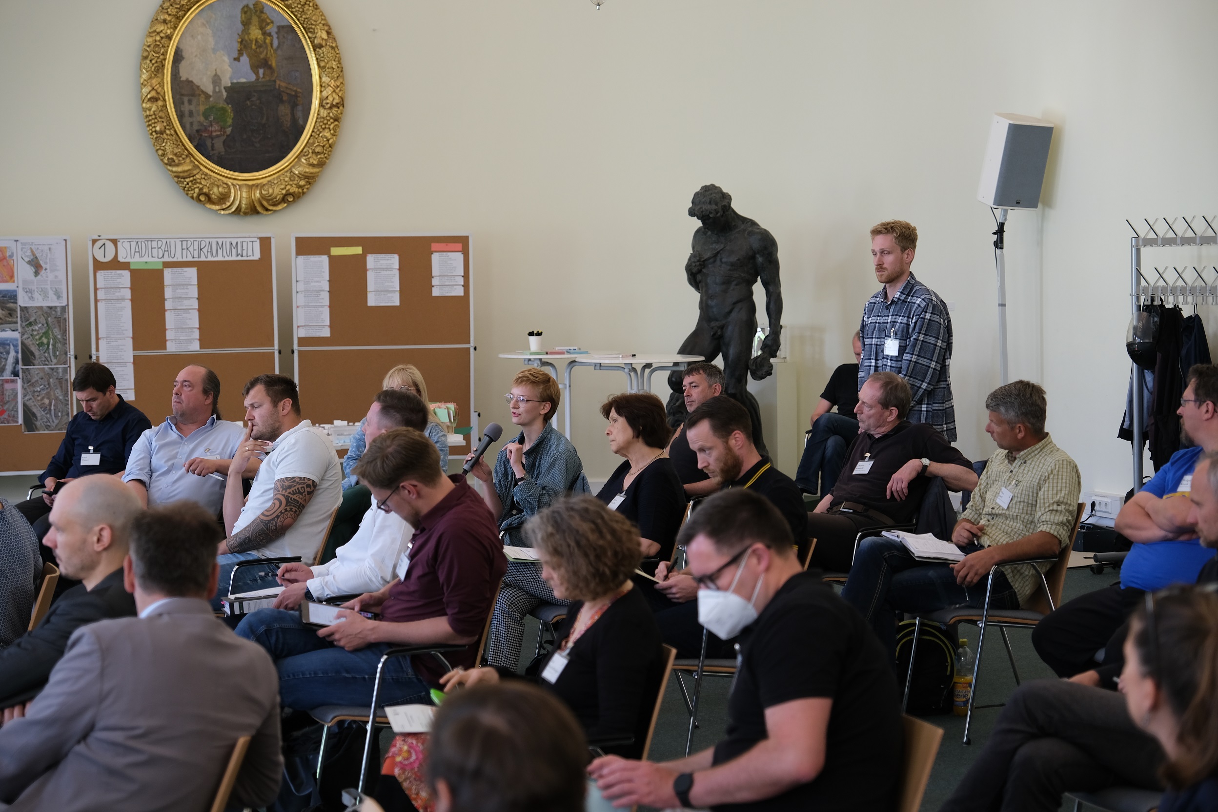 Zu sehen ist ein Teil der Begleitgruppe beim 2. Arbeitstreffen am 21. Mai 2022 im Stadtmuseum Dresden. Eine Bürgerin beteiligt sich an der Diskussion.