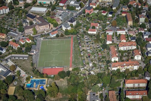 Auf einem Luftbild sind am unteren linken Bildrand das Hebbelbad, im Mittelgrund ein großer Sportplatz und am oberen linken Bildrand das Volkshaus Cotta zu sehen.