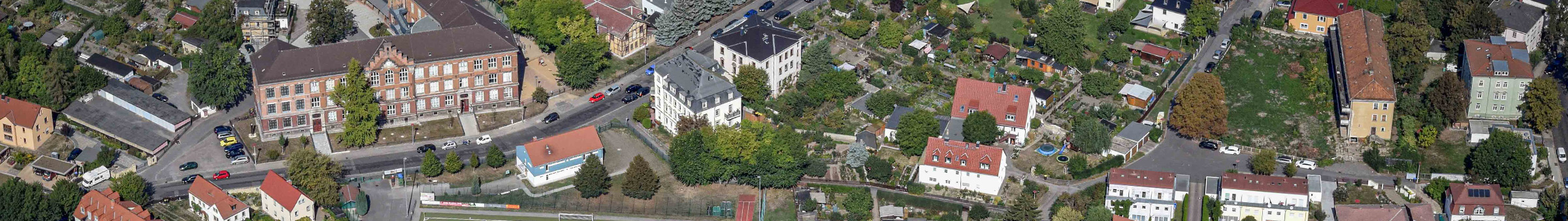 Auf einem Luftbild sind die Stadtteile Löbtau, Gorbitz, Cotta und Briesnitz zu sehen. Am unteren Bildrand verläuft die Kesselsdorfer Straße. Im Mittelgrund sind Hochhausblöcke zu sehen. Den Abschluss bildet am oberen Bildrand die Elbe.
