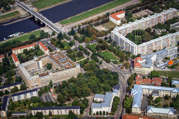 Auf einem Luftbild ist im Zentrum der Sachsenplatz zu sehen. Im Umfeld ordnen sich baulich das Amtsgericht Dresden, die Hochhäuser der Johannstadt sowie am oberen Bildrand die Elbe mit der Albterbrücke ein.