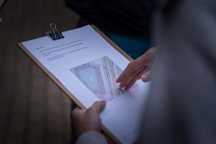 Bürger mit Klemmbrett und Karte im Rahmen einer Bürgerbeteiligung.
