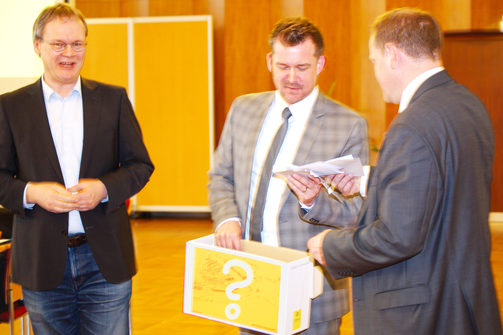 Baubürgermeister Schmidt-Lamontain mit der Losbox und die Stadträte Tilo Wirtz und Gunter Thiele