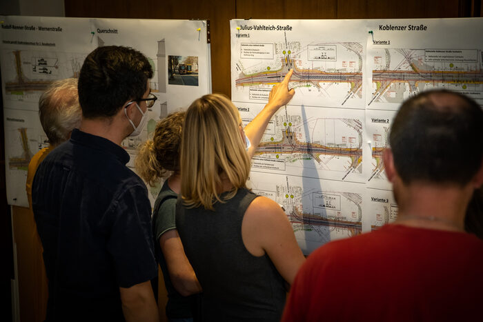 Das Foto zeigt Bürgerinnen und Bürger, die Pläne zum Kreuzungsbereich Julius-Vahlteich-Straße sichten.