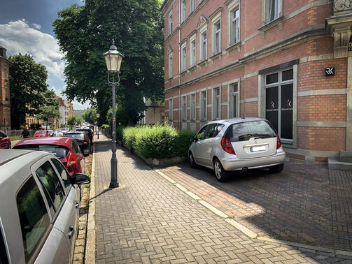 Auf einem Bild wird die Parksituation auf einer Nebenstraße in Löbtau deutlich. Ein Fahrzeug steht auf dem Fußweg.