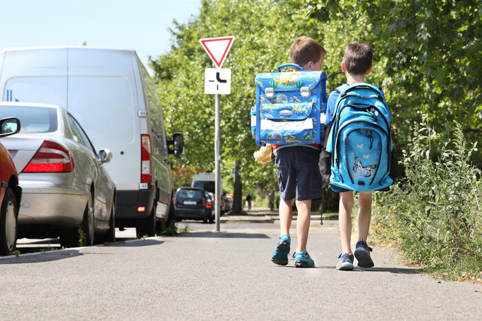 Zwei Kinder mit Ranzen auf dem Schulweg