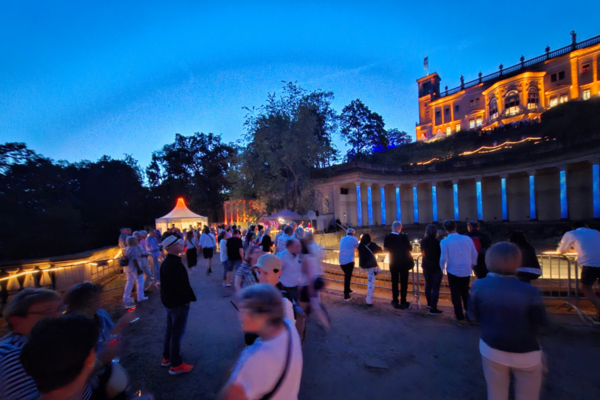 Beleuchtete Säulen und Menschen davor.