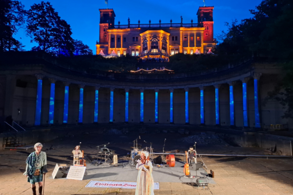 Beleuchtete Säulen und Menschen davor.