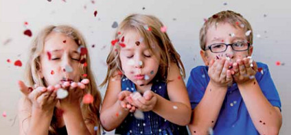 Kinder pusten buntes Papier in Luft. Foto: getty images/Fun energetic ecelectic