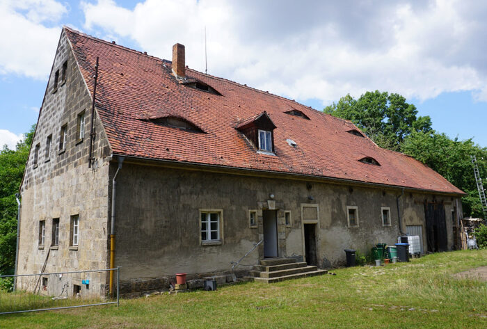 Ländlich geprägtes zweigeschossiges Einfamilienhaus mit rotem Satteldach, nicht modernisiert.
