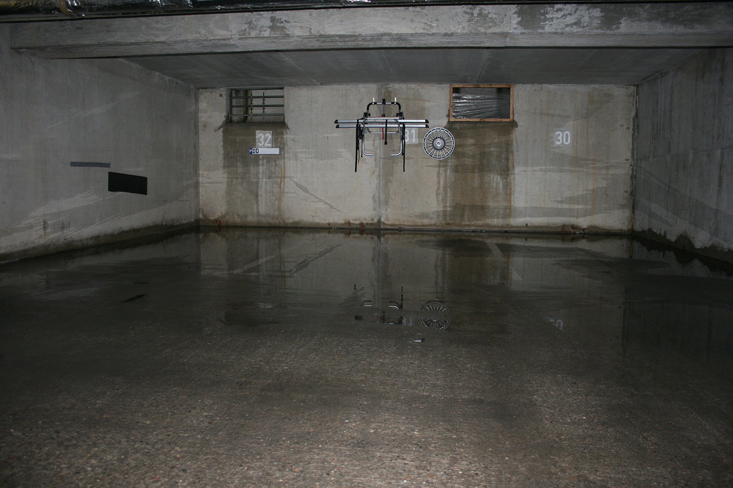 In einer Tiefgarage ist der Boden mehrere Zentimeter von Wasser überflutet.