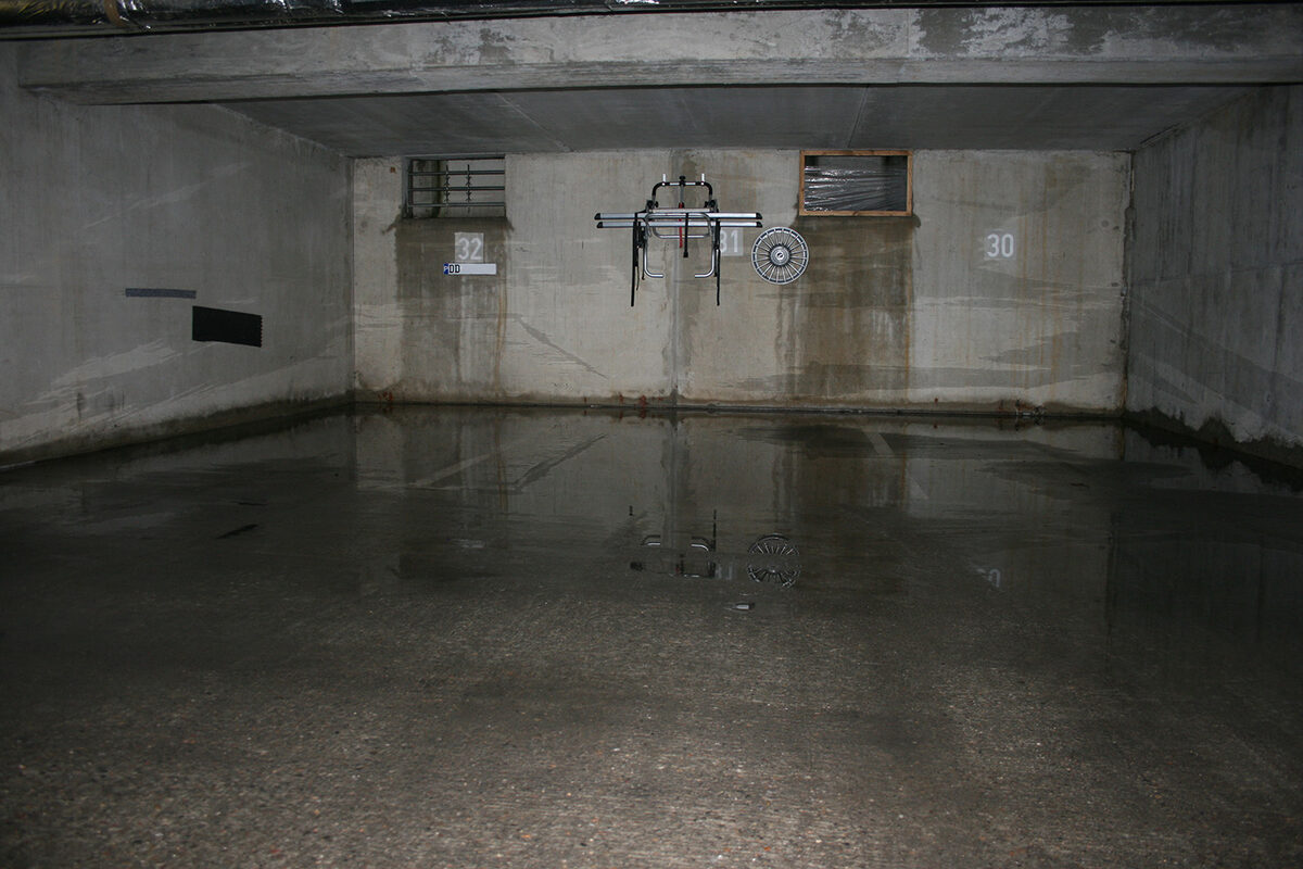 In einer Tiefgarage ist der Boden mehrere Zentimeter von Wasser überflutet.