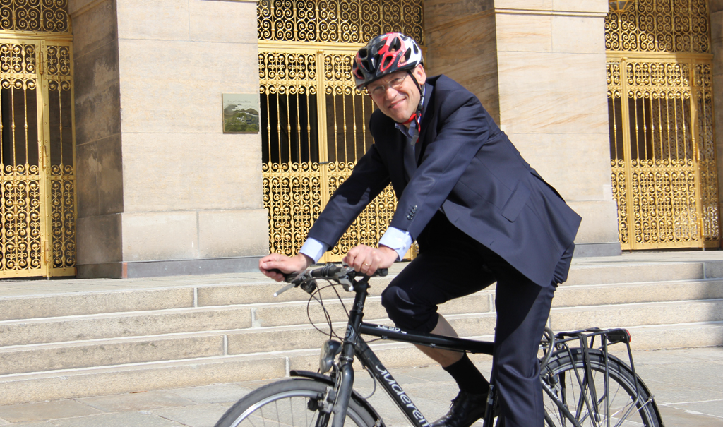 Dr. Peter Lames auf dem Fahrrad vor der goldenen Pforte