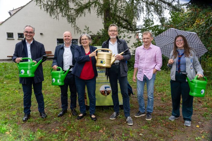 Übergabe der Goldenen Gießkanne zur Würdigung des Gießengagements an (von links): Dr. Florian Reißmann, Mitglied des Kirchenvorstandes Weinbergskirche Dresden-Trachenberge; Ralf Strothteicher, Technischer Geschäftsführer der Stadtentwässerung Dresden GmbH; Eva Jähnigen, Bürgermeisterin für Umwelt, Klima, Recht und Ordnung der Landeshauptstadt Dresden; Dr. Peter Skyba, Gießkannenheld:innen Dresden; Tom Umbreit, Geschäftsführer Umweltzentrum Dresden sowie Davida Bäcker, Vertreterin der Pfadfinder:innen der Weinbergskirche Dresden-Trachenberge