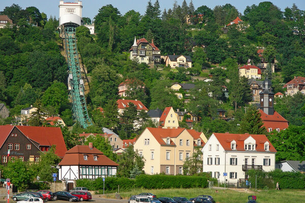 Häuser am Hang und Bergschwebebahnstrecke mit Bergstation