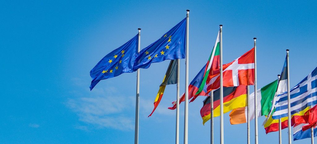 Die EU-Flagge und anderen Flaggen von EU-Staaten vor blauem Himmel