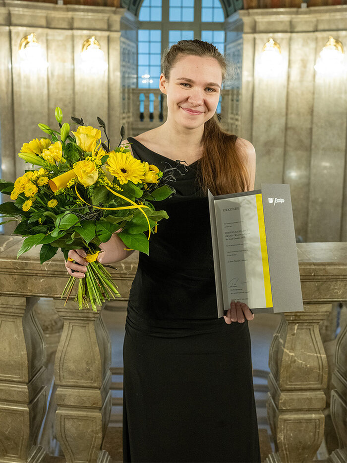Natalie Lehnart, Preisträgerin Dresden Excellence Award 2022 Stufe Bachelor, mit Blumenstrauß und Urkunde