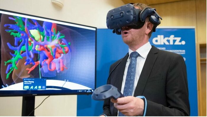 Michael Kretschmer betrachtet mithilfe einer VR-Brille eine vom Krebs befallene Leber.