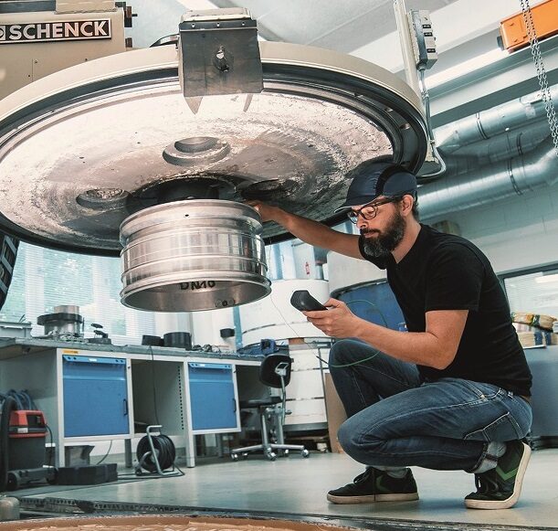 Ein Mitarbeiter des Instituts für Kunstofftechnik und Leichtbau testet an einer Maschine.