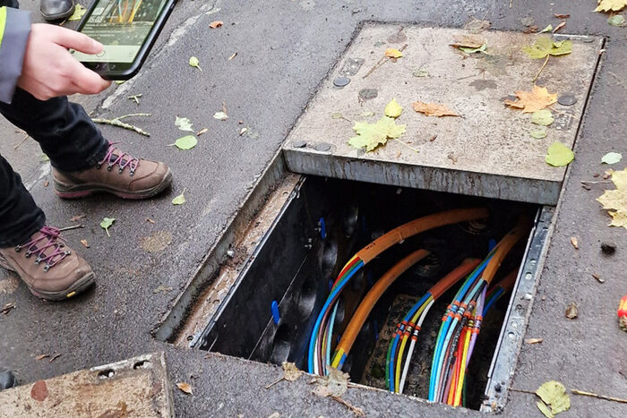 Blick in einen Kanal mit verlegten Glasfaserkabeln