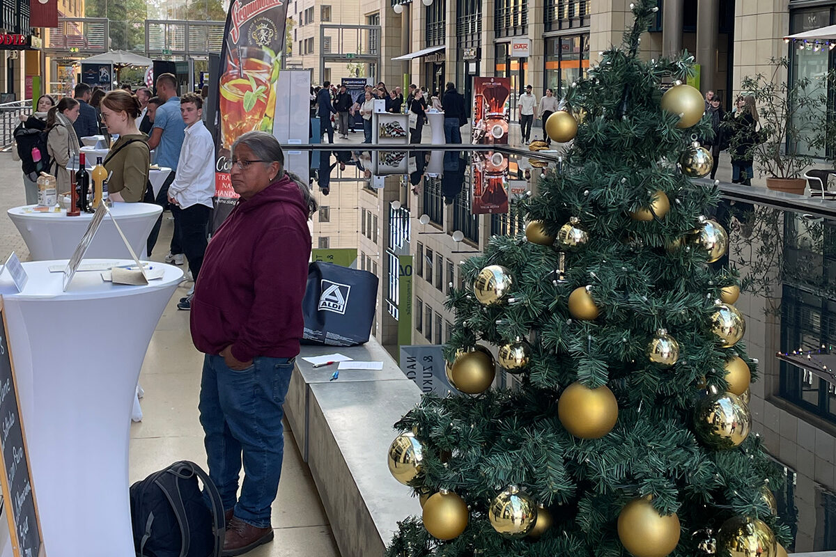 Teilnehmer an der Dresdner Jobbörse Weihnachtsmarkthändler neben Weihnachtsbaum