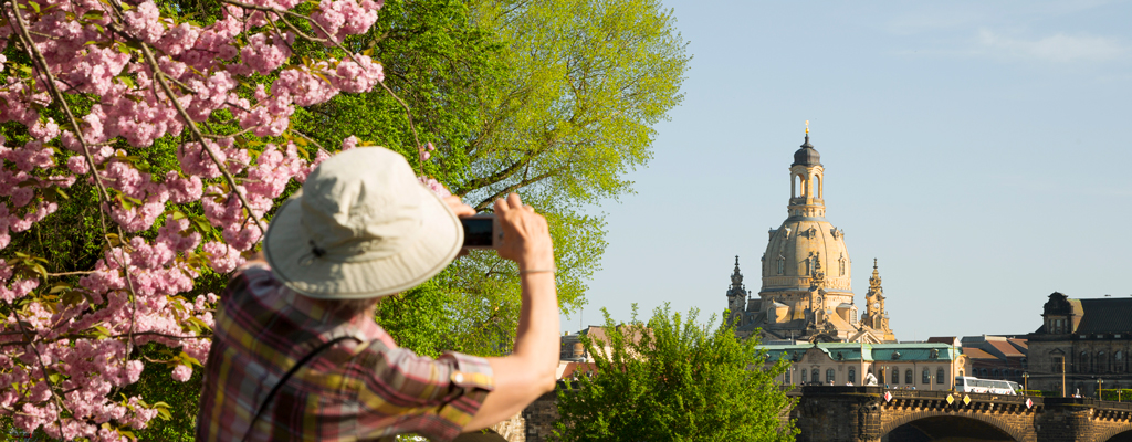 Tourist beim Fotografieren der Dresdner Frauenkirche im Frühling