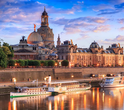 Famous Dresden city backdrop with Frauenkirche, Brühl Terrace and the steamships on the Elbe at sunset.