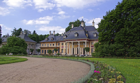 Blick auf das Schloss und die blühenden Beete des Parks Pillnitz