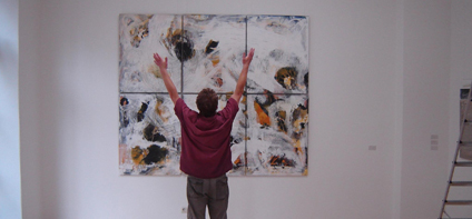 Ein Mann betrachtet ein Gemälde in einer Galerie und streckt dabei begeistert seine Arme nach oben