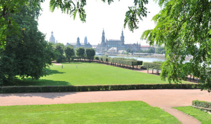 Blick auf den Garten des Japanischen Palais im Sommer, in der Ferne ist die Stadtsilhouette erkennbar