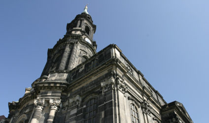 Detailaufnahme des Turms der Kreuzkirche von unten vor klarem Himmel.