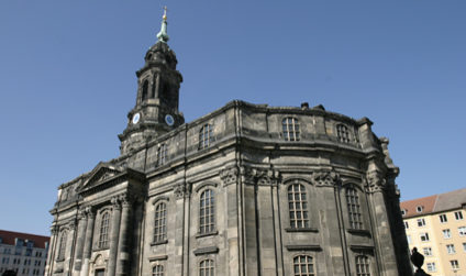 Rückansicht der Dresdner Kreuzkirche von unten vor klarem Himmel.