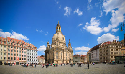Touristengruppen und Besucher vor der Frauenkirche am Neumarkt im Sommer mit blauem Himmel.