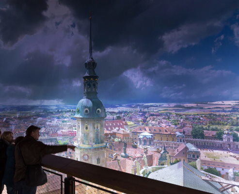 Besucher stehen auf einer Plattform und blicken auf ein barockes Dresden als Panorama im Panometer Dresden.