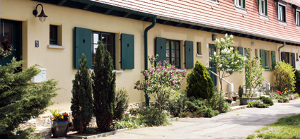 Häuserfront mit aufwendig bepflanzten Hauseingängen in der Gartenstadt Hellerau