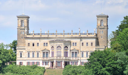 Frontansicht des Schloss Albrechtsberg umgeben von blühender Natur