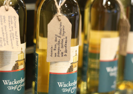 Schloss Wackerbarth Weißwein in Flaschen mit handgeschriebener Beschreibung auf einem Schildchen