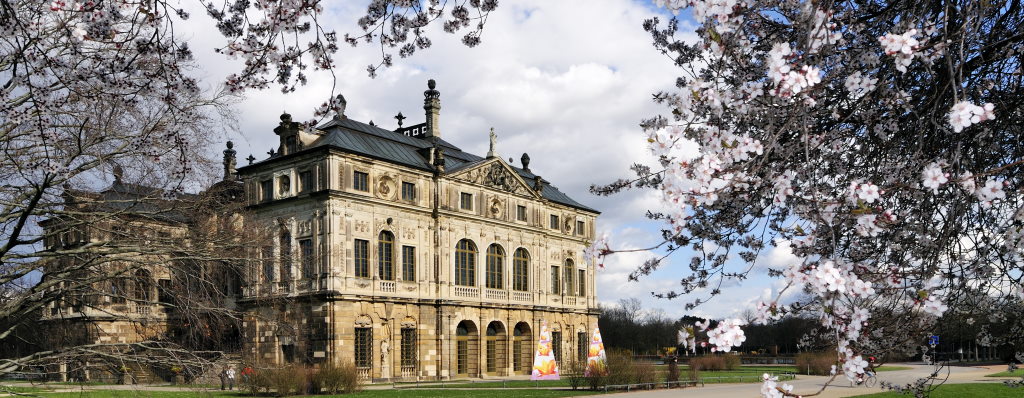 Das Palais im Großen Garten in der Frühlingszeit. Oben und rechts am Bildrand blühen die ersten Bäume.