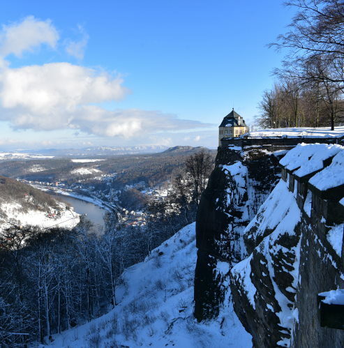 Blick auf einen verschneiten Teil der Festung Königstein zur Winterzeit.