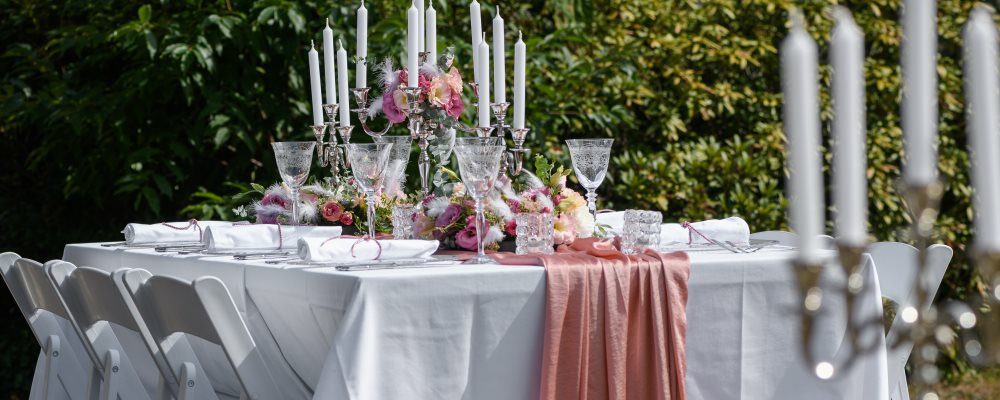 Ein gedeckter Tisch mit Kerzenständer, Geschirr und Dekoration.