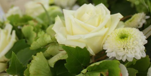 Ein Blumengesteck mit weißen Rosen.